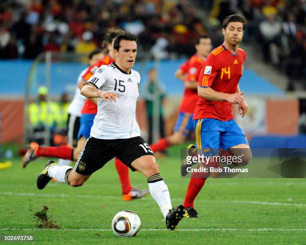 Piotr Trochowski of Germany with Xabi Alonso of Spain during the 2010 FIFA World Cup South Africa Semi Final match between Germany and Spain at...