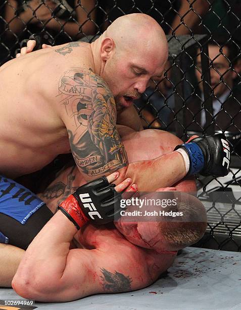 Shane Carwin holds down Brock Lesnar in the first round during the UFC Heavyweight Championship Unification bout at the MGM Grand Garden Arena on...