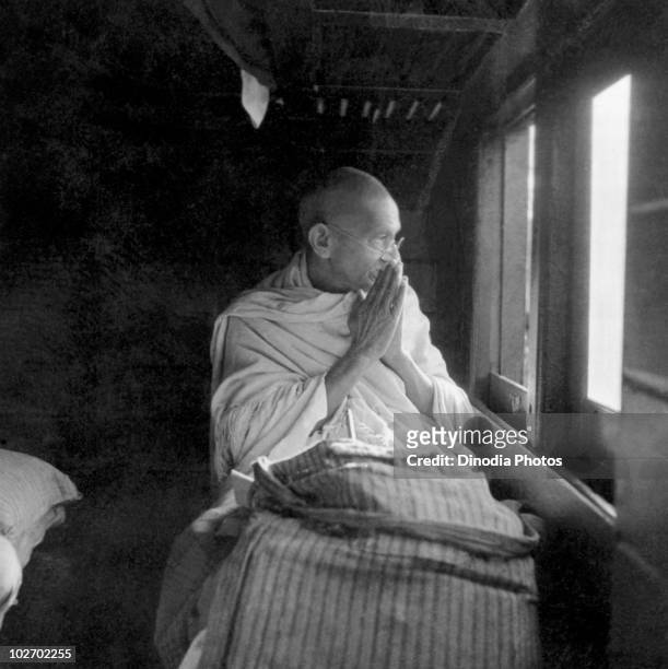Indian statesman and activist Mohandas Karamchand Gandhi greets people through the window of a train, 1940.