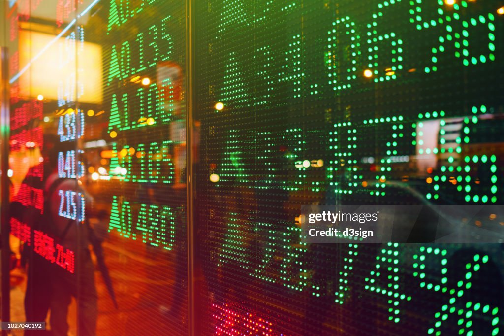 Stock exchange market display screen board on the street showing stock rises in green colour