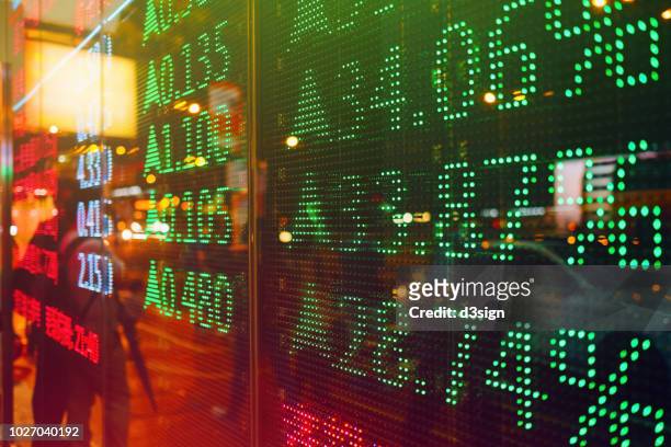 stock exchange market display screen board on the street showing stock rises in green colour - trading screen stock pictures, royalty-free photos & images