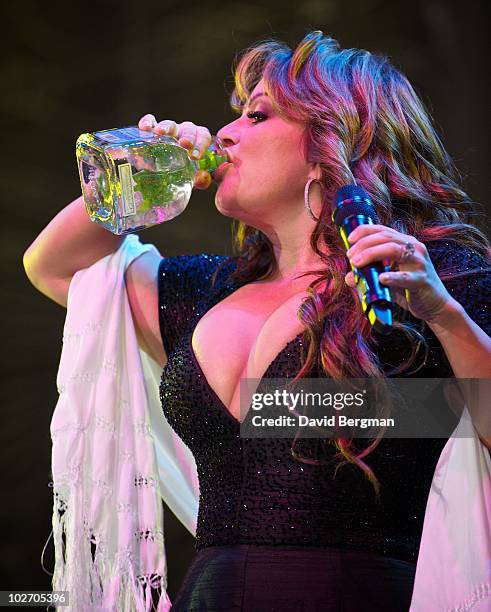 Jenni Rivera drinks tequila during her performance at 2010 Lilith Fair at Cricket Wireless Amphitheatre on July 7, 2010 in San Diego, California.