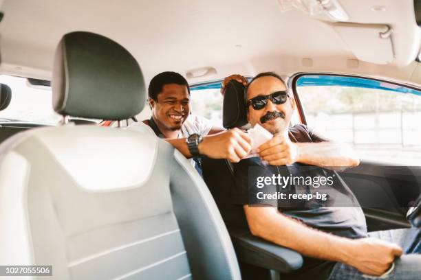 african tourist paying taxi fare - taxi driver stock pictures, royalty-free photos & images
