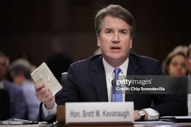 Supreme Court nominee Judge Brett Kavanaugh holds up a small copy of the U.S. Constitution while answering questions before the Senate Judiciary...