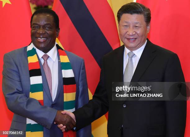 Chinese President Xi Jinping shakes hands with Zimbabwe's President Emmerson Mnangagwa at a meeting at the Great Hall of the People in Beijing on...