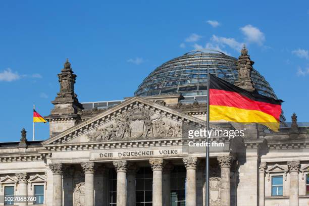 reichstag building - the famous inscription on the architrave on the west portal of the reichstag building in berlin: "dem deutschen volke" with german flag (germany) - bundestag stock pictures, royalty-free photos & images