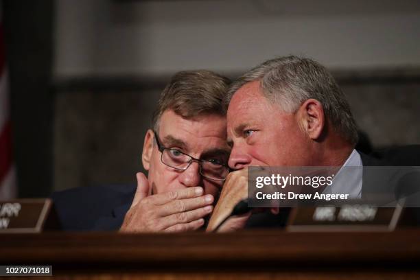 Committee ranking member Sen. Mark Warner talks with committee chairman Sen. Richard Burr during a Senate Intelligence Committee hearing concerning...