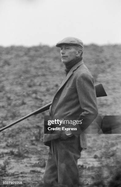 British Conservative Party politician and Prime Minister of the United Kingdom, Alec Douglas-Home pictured holding a shotgun whilst shooting at an...