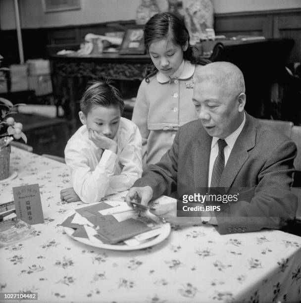 Man reads out Chinese New Year's goodwill messages to his grandchildren, New York City, 28th January 1960.