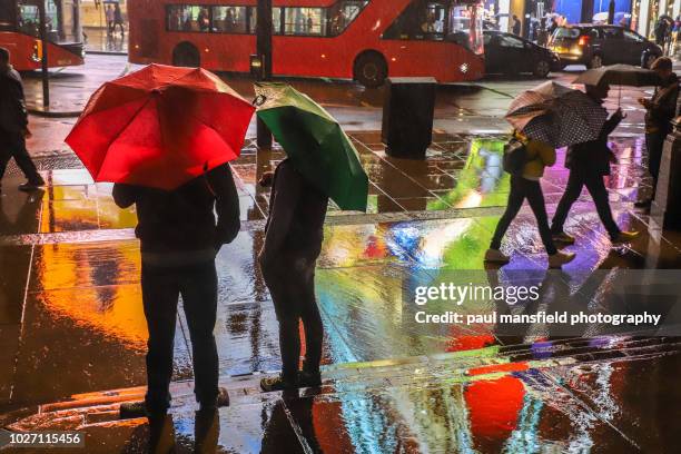 city scene at night in rain - london buses stock-fotos und bilder