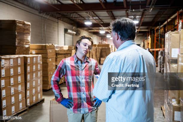 倉庫經理與年輕的倉庫工人交談。 - 處罰 個照片及圖片檔