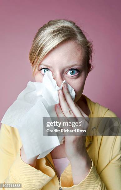 woman with a cold / allergies blowing her nose - papiertaschentuch stock-fotos und bilder