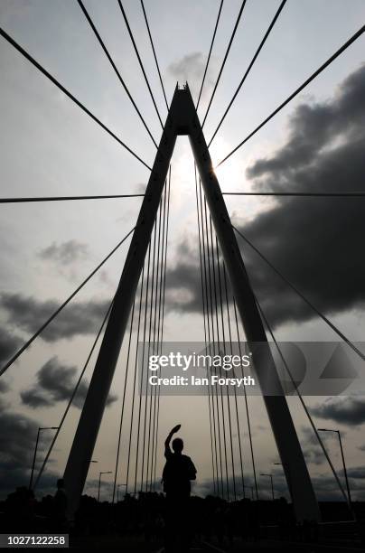 Man shields his eyes from the sun as he looks up at the central pylon of the new Northern Spire bridge spanning the River Wear as it opens for a...