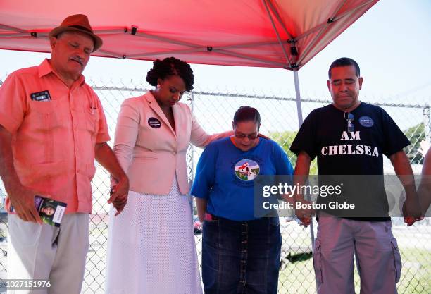 Massachusetts Congressional candidate and Boston City Councilor Ayanna Pressley, second from left, holds hands with Rev. Francisco Caro of Iglesia de...