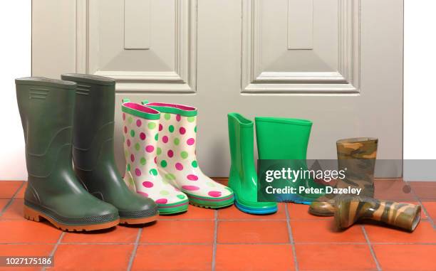 family's outdoor boots by outside door - family shoes fotografías e imágenes de stock