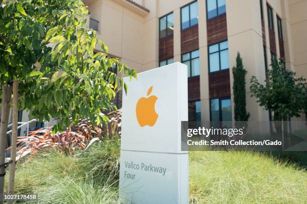 Low-angle view of orange colored logo on sign near the headquarters of Apple Computers in the Silicon Valley, Cupertino, California, August 26, 2018.