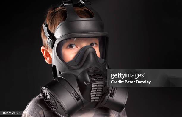 young boy wearing gas mask - chemical attack stock-fotos und bilder