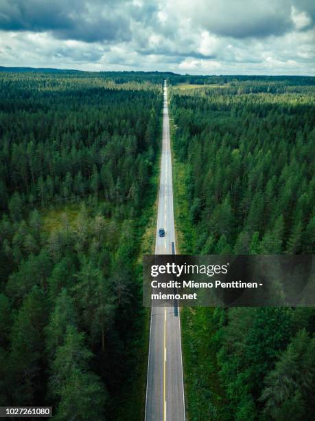 aerial view of a long straight of a country road in the middle of a forest in finland - car nature ストックフォトと画像