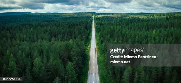 aerial view of a long straight of a country road in the middle of a forest in finland - panoramic road stock pictures, royalty-free photos & images