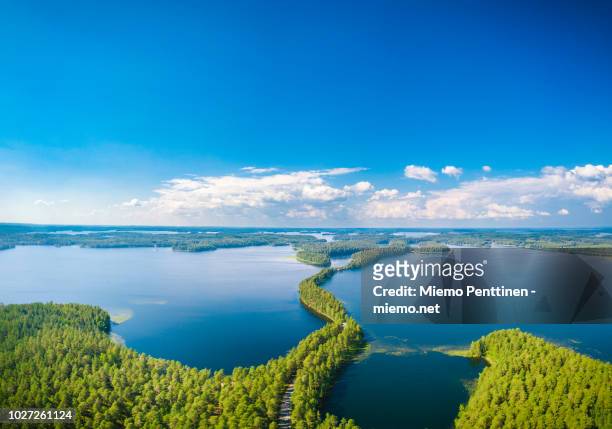 aerial view of a narrow stretch of land crossing a lake in punkaharju, finland on a sunny summer day - finland stock pictures, royalty-free photos & images