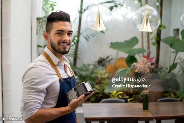 kellner arbeiten in einem restaurant hält eine eftpos - poes stock-fotos und bilder