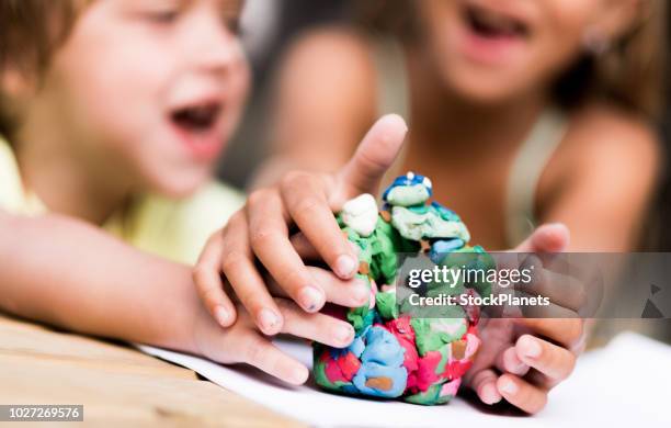 niños discutiendo sobre plastilina - amoldar fotografías e imágenes de stock