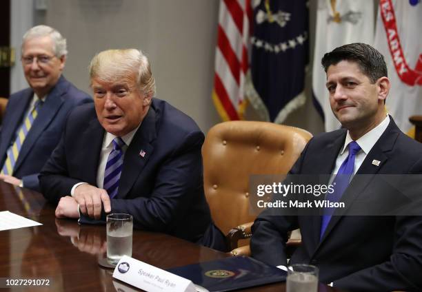 President Donald Trump is flanked by Senate Majority Leader Mitch McConnell , , and House Majority Leader Paul Ryan , while speaking during a meeting...