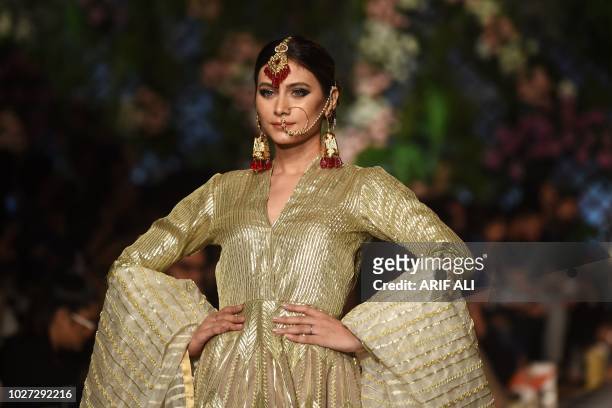 Model presents a creation of designer Nadia Azwer during the Pakistan Fashion Design Council L'Oreal Paris Bridal Week 2018, in Lahore on September...