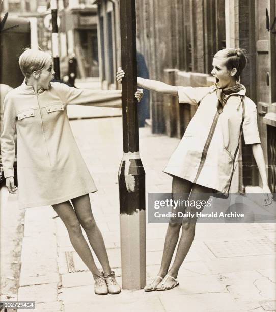 Twiggy with lookalike competition winner, 1967. A photograph of Twiggy , real name Lesley Hornby , with Kerstin Lindberg, swinging round a lamppost...