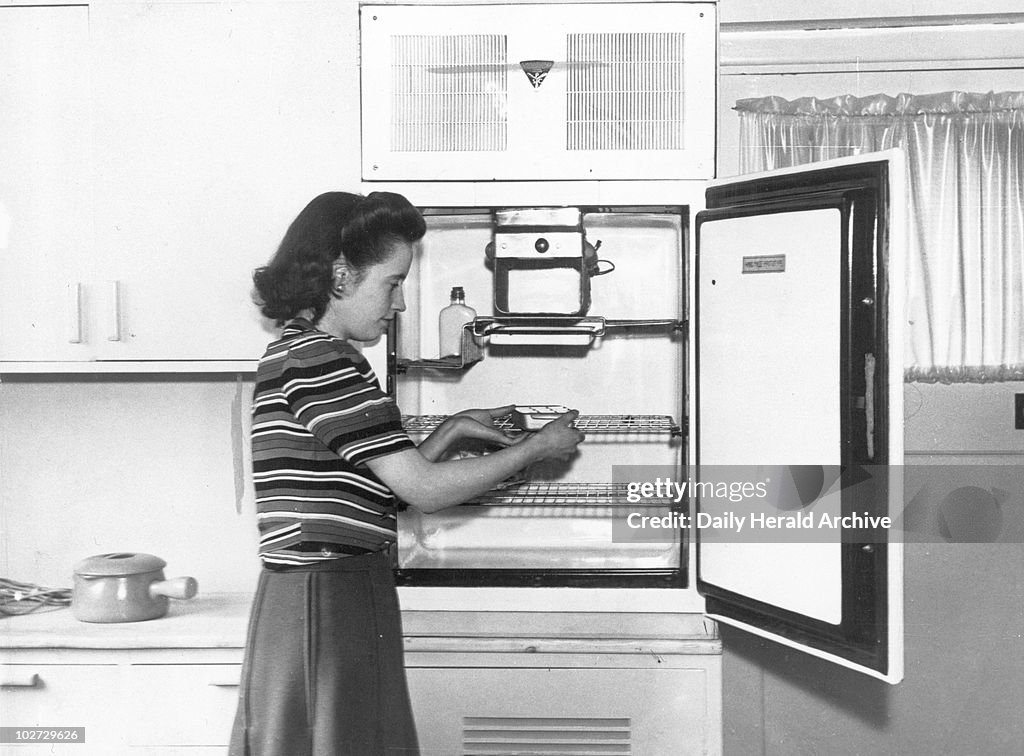 Woman demonstrating the latest refrigerator, 1946.