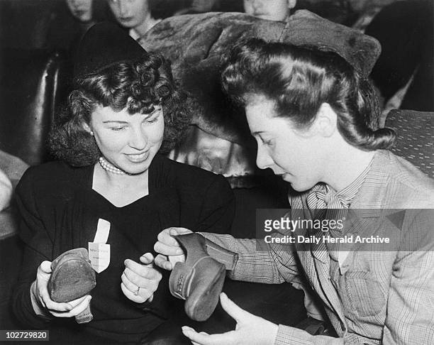 Brides admiring new stockings and shoes, 17 December 1945. 'GI brides had another of their fortnightly meetings at 72 Seymore Street where they...