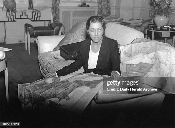 Amy Johnson, British aviator, 17 November 1932. Amy Johnson in a Grosvenor Hotel room studying maps before her solo flight to Cape Town, South...