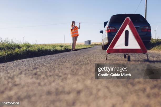 woman phoning and car breakdown. - triángulo-de-advertencia fotografías e imágenes de stock