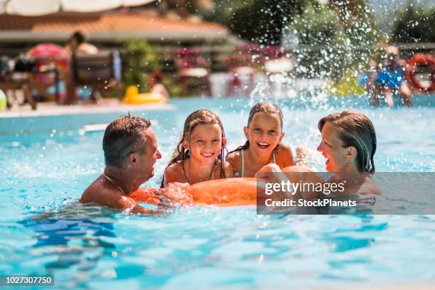 gelukkig gezin genieten in het zwembad - buitenbad stockfoto's en -beelden