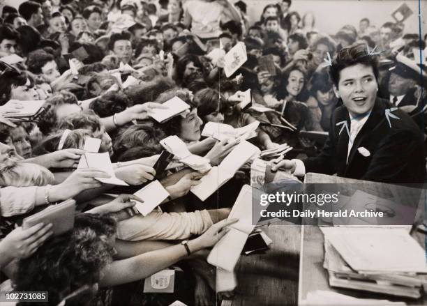 Cliff Richard mobbed by fans, London, 1959. Cliff Richard In Olympias Disc Theatre during the Hultons Girls and Boys exhibition.