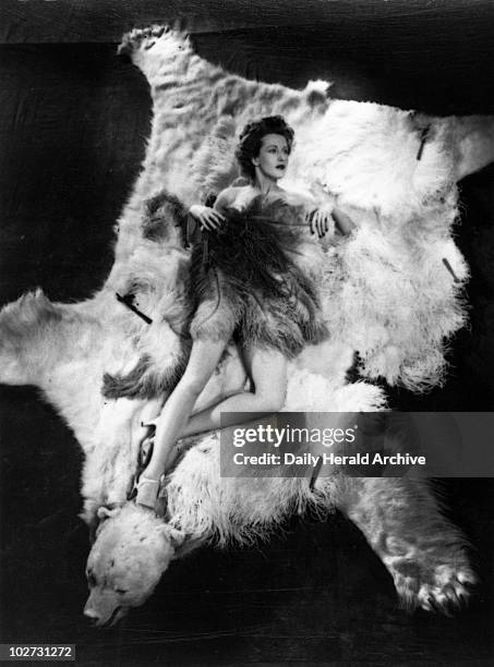 Ann Crawford, 1944." Film actress and pin-up girl, lying on a bear-skin rug, naked but for an ostrich-feather fan."