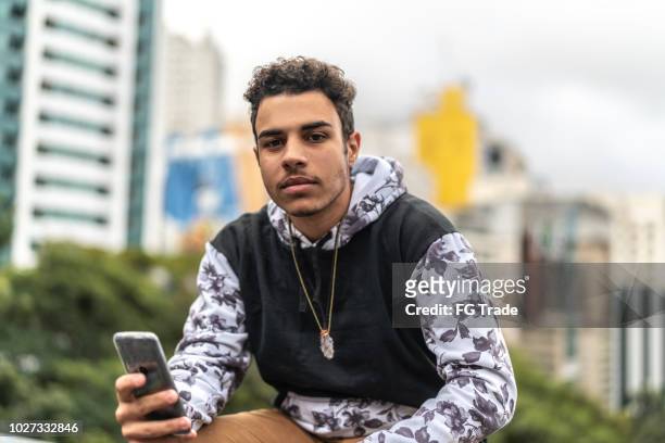 young men using mobile portrait at city on background - serious teenager boy imagens e fotografias de stock