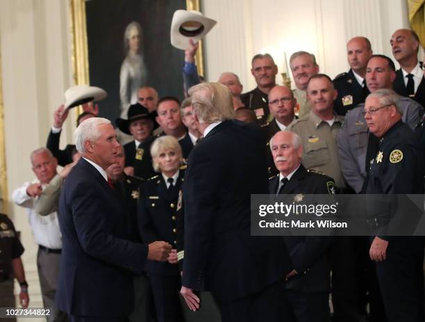 President Donald Trump and Vice President Mike Pence , meet with sheriffs from across the United States during an event in the East Room of the White...