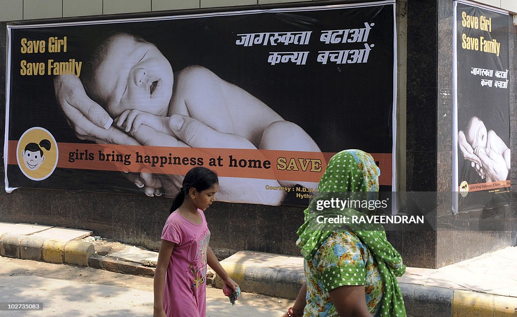 An Indian woman and child walk past a bi