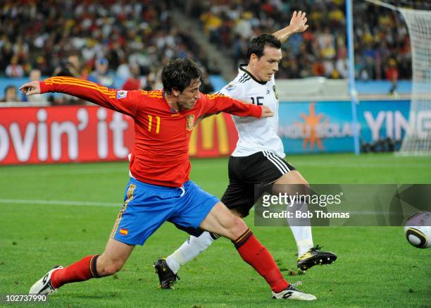 Joan Capdevila of Spain tackled by Piotr Trochowski of Germany during the 2010 FIFA World Cup South Africa Semi Final match between Germany and Spain...
