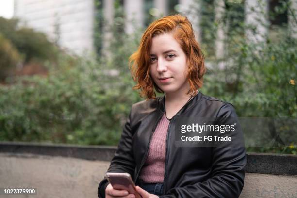young woman with red hair using mobile phone - portrait - woman short hair serious stock pictures, royalty-free photos & images