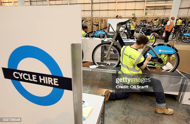 Workers attach information and branding stickers to bicycles which are to be used in London's new cycle hire scheme on July 9, 2010 in London,...