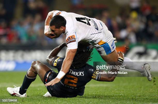 Bodene Thompson of the Titans is tackled by Lote Tuqiri of the Tigers during the round 18 NRL match between the Wests Tigers and the Gold Coast...