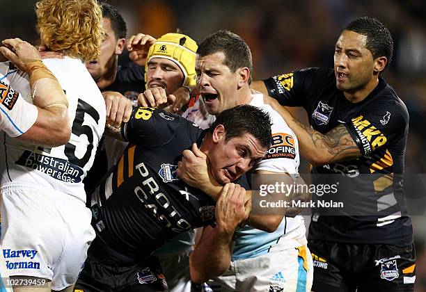 Chris Heighington of the Tigers and Greg Bird of the Titans tussle during the round 18 NRL match between the Wests Tigers and the Gold Coast Titans...