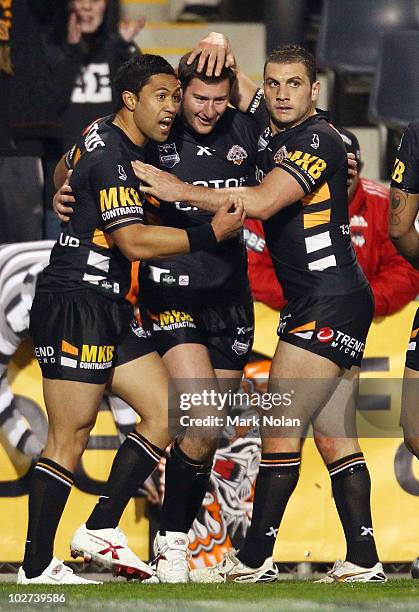 Mitch Brown of the Tigers is congratulated after scoring during the round 18 NRL match between the Wests Tigers and the Gold Coast Titans at...