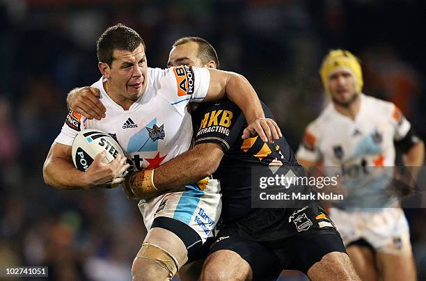 Greg Bird of the Titans is tackled during the round 18 NRL match between the Wests Tigers and the Gold Coast Titans at Campelltown Sports Stadium on...
