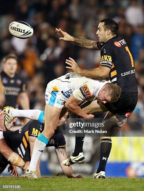 Wade McKinnon of the Tigers offloads during the round 18 NRL match between the Wests Tigers and the Gold Coast Titans at Campelltown Sports Stadium...