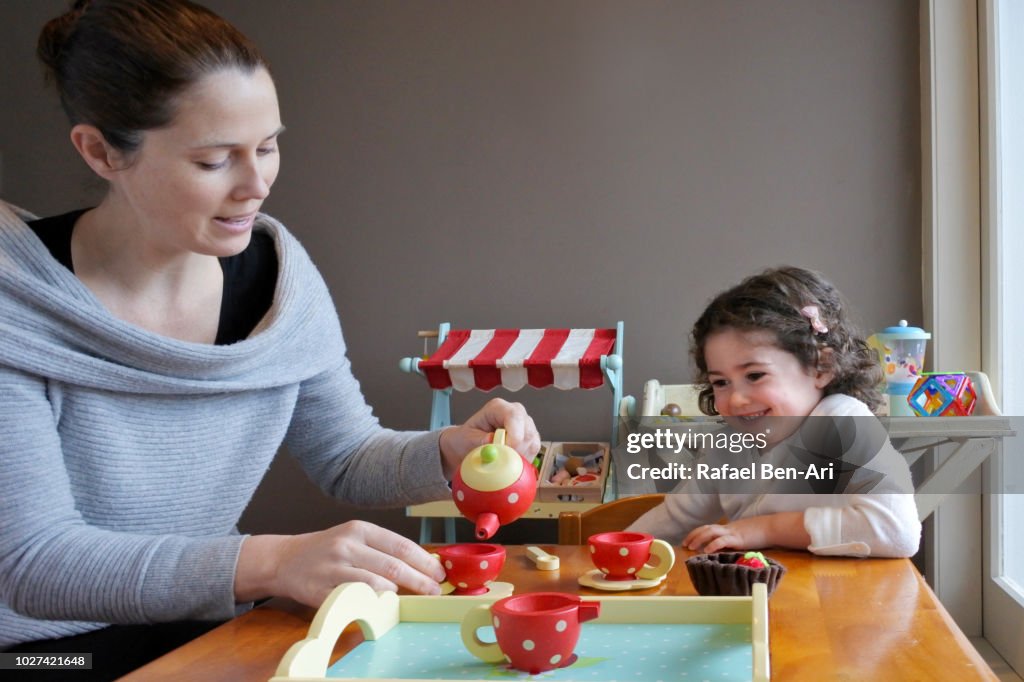 Young Girl is having a Tea Time Party with her Mother