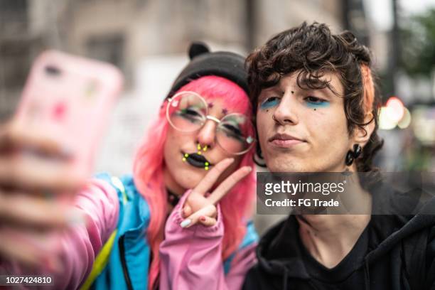 alternative lifestyle young couple taking a selfie - emo stock pictures, royalty-free photos & images