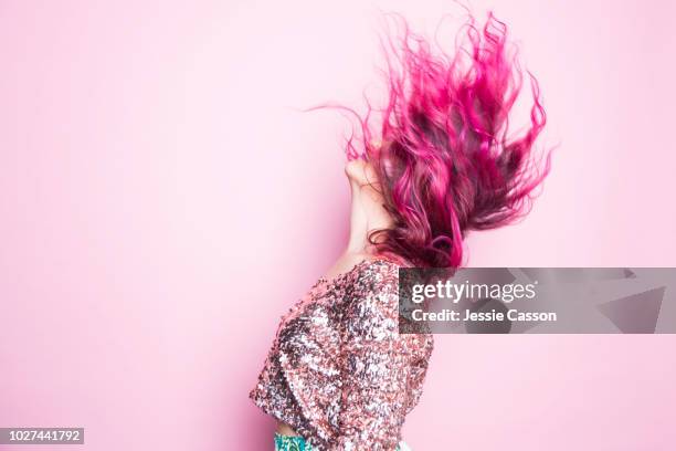 a woman with pink hair throws her head back - shot against a pink background - colore dei capelli foto e immagini stock